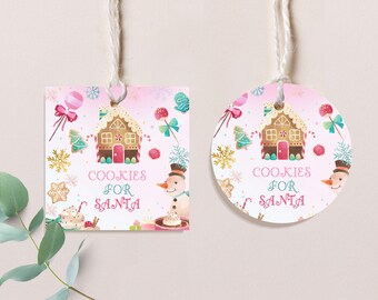 May include: Two Christmas gift tags, one square and one round, with a pink and white background. Each tag features a gingerbread house, snowman, and the text "COOKIES FOR SANTA". The tags are decorated with candy and snowflakes, and are strung with twine.
