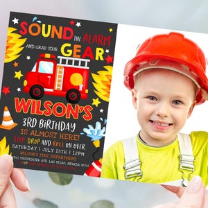 Op de afbeelding: Een rode brandweerwagen met gele vlammen en een zwarte krijtbordachtergrond. De tekst op het krijtbord zegt "Sound the Alarm and Grab Your Gear" en "Wilson's 3rd Birthday is Almost Here! Stop Drop and Roll on Over Saturday | July 18th | 12PM Wilson's Fire Department 345 Firefighter Ave Las Vegas, Nevada 96765 RSVP". Een foto van een kind met een rode helm en een geel shirt is aan de rechterkant van de uitnodiging.