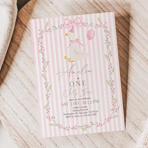 May include: A pink and white striped invitation card with a watercolor illustration of a goose wearing a bow and holding a balloon. The text reads "Amelia is ONE" and includes event details.