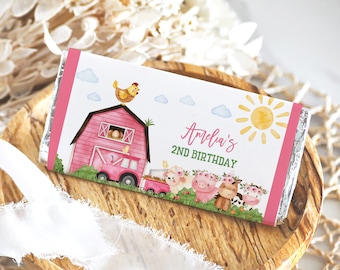 Puede incluir: Envoltorio de barra de chocolate rosa y blanco con temática de granja. Presenta un granero rojo, una gallina, un camión y animales de granja. El texto en el envoltorio dice "Amelia's 2nd Birthday".