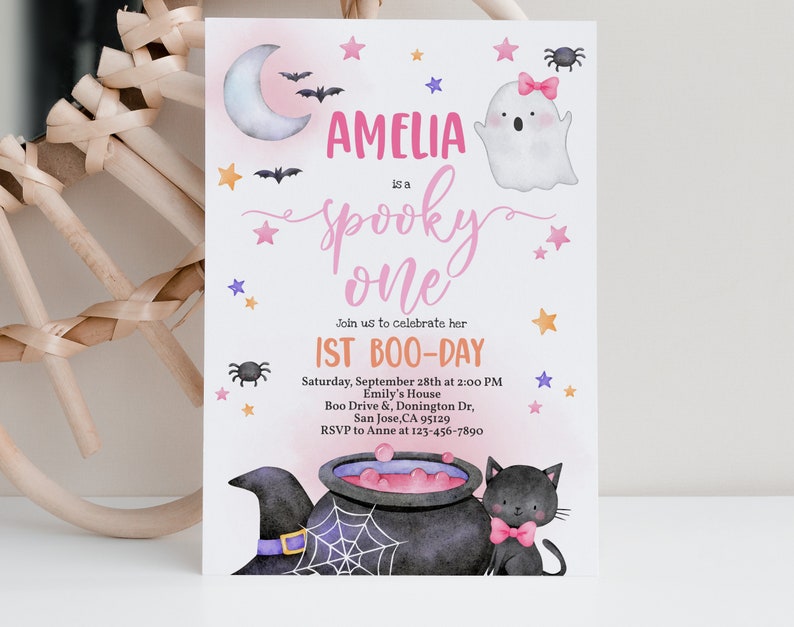 May include: A pink and white Halloween party invitation with a ghost, bats, stars, and a cauldron. The text reads "Amelia is a spooky one. Join us to celebrate her 1st Boo-Day. Saturday, September 28th at 2:00 PM. Emily's House. Boo Drive & Donington Dr, San Jose, CA 95129. RSVP to Anne at 123-456-7890."