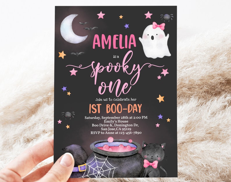 May include: A black and white invitation card with a pink and white ghost, a black cat, and a cauldron. The text on the card reads "Amelia is a spooky one. Join us to celebrate her 1st Boo-Day. Saturday, September 28th at 2:00 PM. Emily's House. Boo Drive & Donington Dr, San Jose, CA 95129. RSVP to Anne at 123-456-7890."