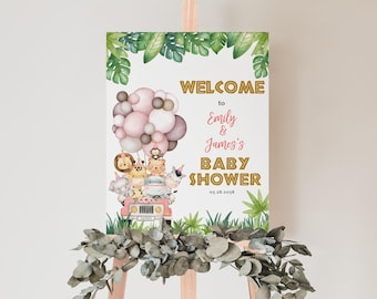 May include: Welcome to Emily & James's Baby Shower sign with a pink and white jeep with animal passengers and pink and white balloons. The sign is decorated with green leaves.