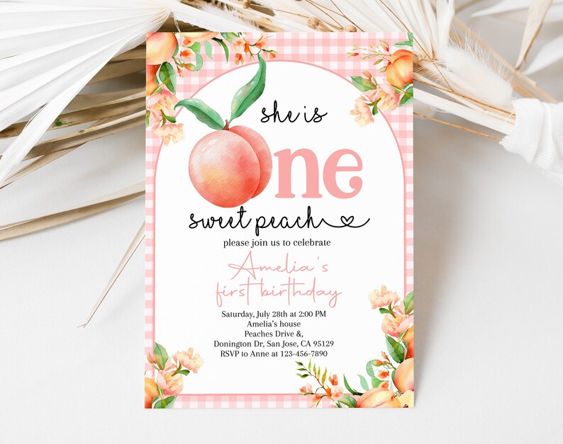 Op de afbeelding: Roze en witte gingham achtergrond met een perzikillustratie en de tekst "she is one sweet peach" en een hartje. De tekst "please join us to celebrate Amelia's first birthday" staat onder de perzik. De uitnodiging bevat de datum, tijd, locatie en RSVP-informatie.