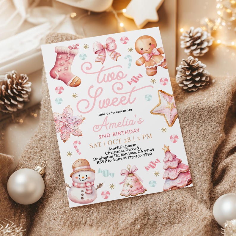 May include: Pink and white invitation card with a gingerbread theme. The card says "Two Sweet" and "Amelia's 2nd Birthday". The card has a gingerbread man, a gingerbread stocking, a gingerbread star, a gingerbread tree, and a snowman.