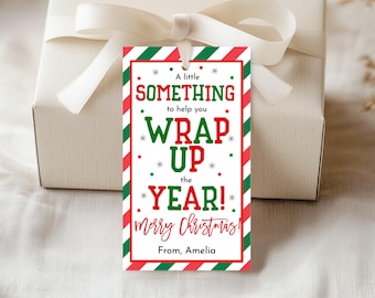 May include: A gift tag with a red and green border and the text "A little SOMETHING to help you WRAP UP the YEAR! Merry Christmas! From, Amelia" is attached to a wrapped gift with a white ribbon.