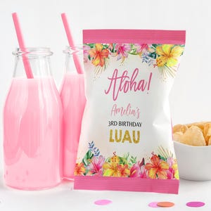 May include: A festive party scene with pink drinks in glass bottles with straws, a bag of chips, and a decorated chip bag with the words "Aloha! Amelia's 3rd Birthday Luau". The chip bag has a floral design.