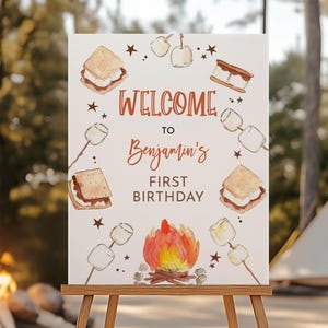 Könnte beinhalten: Ein Willkommensschild für Benjamins ersten Geburtstag mit Lagerfeuer-Motiv. Das Schild zeigt Illustrationen von S'mores, Marshmallows und einem Lagerfeuer. Der Text lautet "Willkommen zu Benjamins erstem Geburtstag."