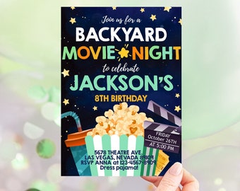 May include: A blue and green invitation for a backyard movie night to celebrate Jackson's 8th birthday. The invitation features a movie clapperboard, popcorn, a drink, and stars. The text reads "Join us for a Backyard Movie Night to celebrate Jackson's 8th Birthday. Friday, October 26th at 5:00 PM. 5678 Theatre Ave. Las Vegas, Nevada 89109. RSVP Anna at 123-4567-8909. Dress pajama!"
