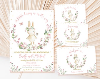 May include: A baby shower invitation with a pink and white floral design featuring a bunny with a flower crown. The text reads "A little bunny is on the way" and includes the names "Emily and Michael".