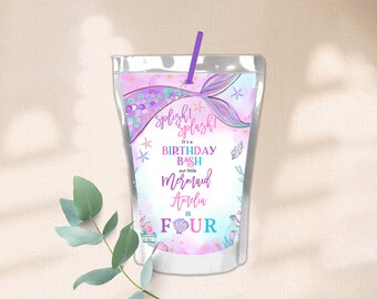 May include: A purple and pink juice box with a mermaid tail design. The text on the box reads "Splish Splash! It's a Birthday Bash our little Mermaid Amelia is Four".