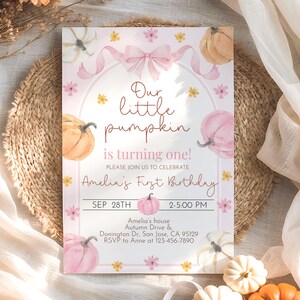 May include: A pink and white invitation card with watercolor pumpkins and floral accents. The text reads "Our little pumpkin is turning one!" and includes details for Amelia's first birthday, such as the date, time, and location.