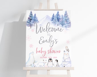 May include: A winter wonderland baby shower welcome sign with a white background, silver glitter text, and pink accents. The text reads "Welcome to Emily's Baby Shower December 28th, 2030". The sign features a watercolor illustration of a snowy mountain, pine trees, and arctic animals including a polar bear, a seal, a penguin, and an owl.