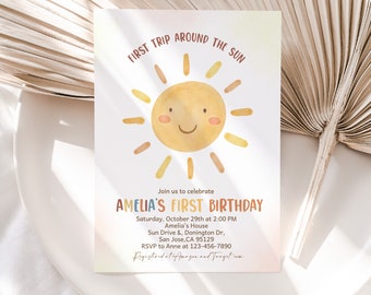 May include: A watercolour illustration of a sun with a smiling face on a white background. The text "First Trip Around The Sun" is at the top of the card. The text "Amelia's First Birthday" is in colourful letters below the sun. The text "Saturday, October 29th at 2:00 PM" is below the birthday text. The text "Amelia's House" is below the date and time. The text "Sun Drive & Donington Dr, San Jose, CA 95129" is below the house address. The text "RSVP to Anne at 123-456-7890" is below the city, state, and zip code. The text "Registered at Amazon and Target.com" is at the bottom of the card.