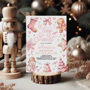May include: Pink and white invitation card with the text "Two Sweet" and "Amelia's 2nd Birthday". The card is decorated with gingerbread cookies, candy canes, and other Christmas-themed illustrations.