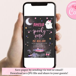 May include: A printable Halloween party invitation for a girl's first birthday. The invitation features a black background with a pink and purple ghost, a cauldron, and stars. The text reads "Amelia is a Spooky One 1st Boo-Day".