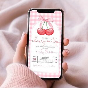 May include: A pink and white gingham patterned baby shower invitation with a red cherry graphic and the text "She is the cherry on top" and "Please join us for a baby shower honouring Emily Brown". The invitation includes the date, time, and location of the event.