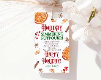 May include: A white gift tag with the text "HOLIDAY SIMMERING POTPOURRI" in red and green. The tag features watercolor illustrations of orange slices, star anise, cinnamon sticks, and berries. Instructions are included.