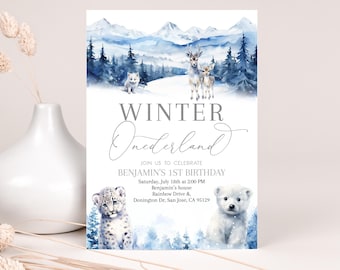 Peut inclure: Une invitation à un premier anniversaire sur le thème de l'hiver. L'arrière-plan aquarelle représente une chaîne de montagnes enneigées, un renard blanc, un cerf et un faon, ainsi qu'un ours polaire. Le texte indique "Winter Wonderland" et "Rejoignez-nous pour célébrer le 1er anniversaire de Benjamin".