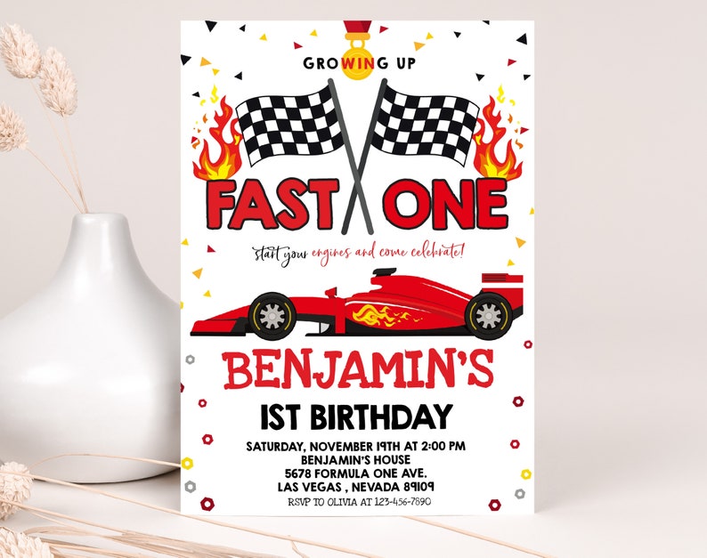 May include: A red and white birthday invitation with a chequered flag, flames, and a red race car. The text reads "Growing Up Fast One" and "Start your engines and come celebrate!"  Benjamin's 1st Birthday. Saturday, November 19th at 2:00 PM. Benjamin's House. 5678 Formula One Ave. Las Vegas, Nevada 89109. RSVP to Olivia at 123-456-7890.