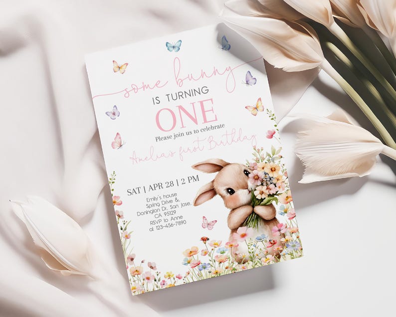 May include: A pink and white invitation card with a bunny holding flowers. The card says "some bunny is turning one" and has butterflies and flowers on it. The text also says "Please join us to celebrate Anelia's first birthday" and includes the date, time, and location of the party.