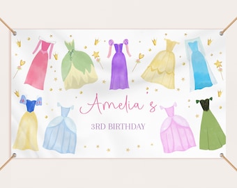 May include: A white banner with a princess theme featuring nine different princess dresses in watercolor style. The banner says "Amelia's 3rd Birthday" in pink lettering.