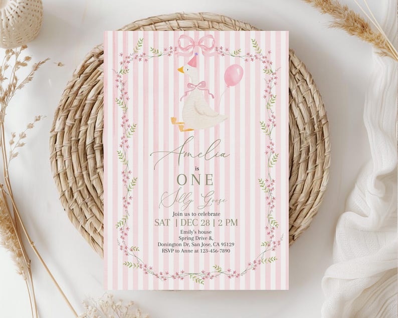 May include: A pink and white striped invitation card with a floral border and a cartoon goose wearing a bow. The text reads "Amelia is ONE Olly Goose" and includes event details.