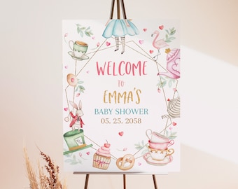 May include: A baby shower welcome sign featuring Alice in Wonderland illustrations. The sign has a pink and gold color scheme with the text "Welcome to Emma's Baby Shower 05.25.2058". The design includes teacups, a flamingo, and a white rabbit.