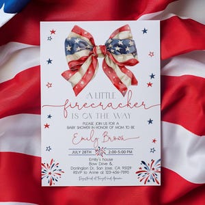 Puede incluir: Una invitaci&oacute;n a un baby shower con tem&aacute;tica patri&oacute;tica. La invitaci&oacute;n presenta un lazo al estilo de la bandera estadounidense, con rayas rojas y blancas y estrellas azules. El texto dice "A Little Firecracker is on the Way."