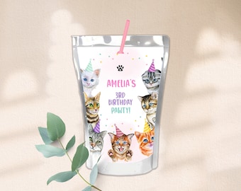 Könnte beinhalten: Ein weißer Saftbeutel mit einem rosa-weißen Etikett mit einem Pfotenabdruck und dem Text "Amelia's 3rd Birthday Pawty!" Das Etikett ist mit sechs Comic-Katzen verziert, die Partyhüte tragen.