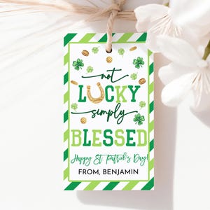 Op de afbeelding: Een St. Patrick's Day cadeaulabel met een groen-witte gestreepte rand. Het label bevat de tekst "not LUCKY simply BLESSED" met klavers, gouden munten en een hoefijzer. Het label zegt ook "Happy St. Patrick's Day!" en "FROM, BENJAMIN."