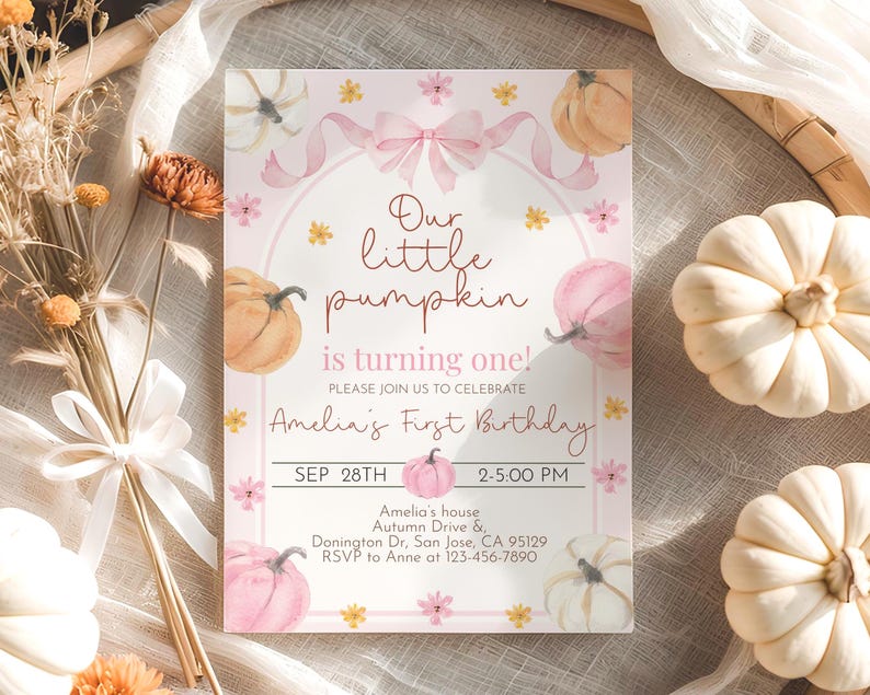 May include: A pink and white invitation card with watercolor pumpkins and floral accents. The text reads "Our little pumpkin is turning one!" and includes the date, time, and location for Amelia's first birthday celebration.