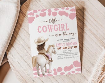 May include: A pink and white baby shower invitation with a cowgirl riding a horse. The text reads "a little cowgirl is on the way".