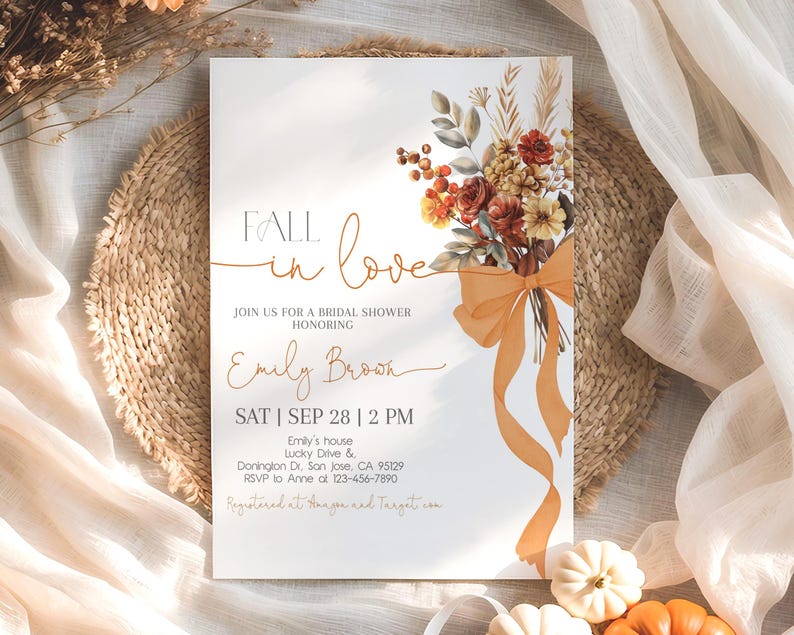 May include: Bridal shower invitation with the text "Fall in Love" and details for Emily Brown's shower. The invitation features a floral bouquet with orange and red flowers and a large orange bow. The background is a neutral color.