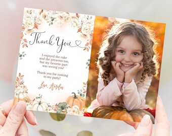 May include: A thank you card featuring a floral border and a photograph of a young girl smiling. The card text reads "Thank You" and includes a message thanking guests for attending the party. The card is decorated with pumpkins and autumn leaves.