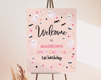 May include: Pink welcome sign with a Halloween theme. The sign says "Welcome to Madison's Spooktacular 1st birthday". The sign is decorated with ghosts, bats, stars, and skulls.