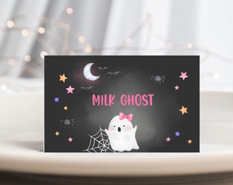 May include: A black chalkboard sign with a white ghost with a pink bow, a crescent moon, bats, and stars. The text "MILK GHOST" is written in pink on the chalkboard.