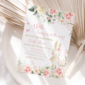 May include: A pink and gold baby shower invitation with a floral design and a cute bunny illustration. The text reads "A little bunny is on the way!" and includes the name "Emily Brown" and details for the shower.