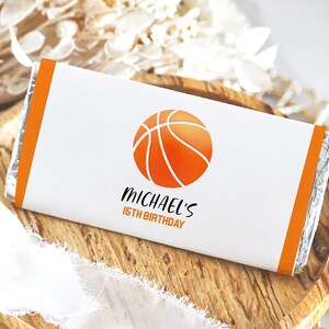 May include: A white chocolate bar wrapper with an orange basketball design and the text "MICHAEL'S 15TH BIRTHDAY".