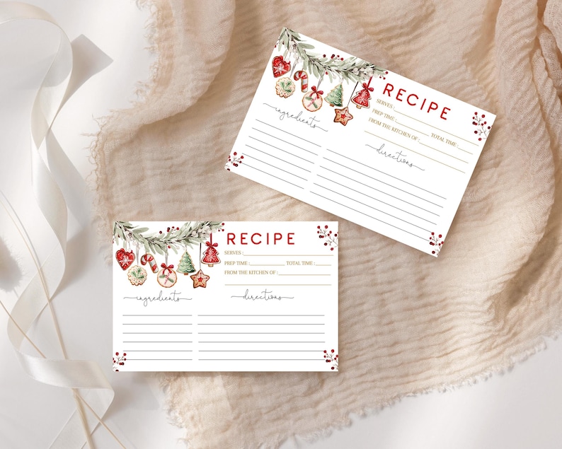 May include: Two white recipe cards with a Christmas theme. Each card has a red "RECIPE" header and lines for ingredients and directions. The cards are decorated with watercolor illustrations of Christmas ornaments and greenery.
