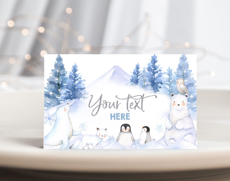 May include: A winter-themed printable card with a snowy mountain scene, blue trees, and a polar bear, penguin, fox, and owl. The text "Your text here" is written in silver glitter font.