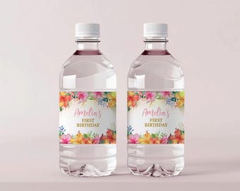 Puede incluir: Dos botellas de agua de plástico transparente con tapas blancas. Cada botella tiene una etiqueta con el texto "Amelia's First Birthday" rodeada de ilustraciones florales coloridas en rosa, naranja y amarillo.