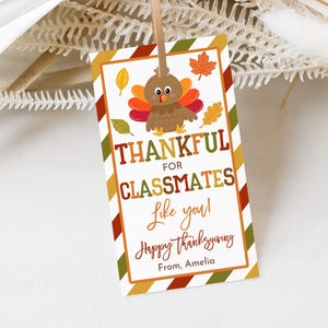 Puede incluir: Etiqueta de regalo de Acción de Gracias con un pavo de dibujos animados, hojas de otoño y el texto "Thankful for Classmates Like You!" en naranja, marrón y verde. La etiqueta es rectangular con un borde marrón y rayas diagonales.