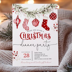 Könnte beinhalten: Eine Einladung zu einem Weihnachtsessen mit einer Aquarell-Illustration von roten und grünen Ornamenten und einem festlichen Kranz. Die Einladung enthält Datum, Uhrzeit, Ort und RSVP-Informationen. "Bitte schließen Sie sich uns zu einem Weihnachtsessen an" ist in roten und schwarzen Buchstaben geschrieben.  "Samstag, 28. Dezember" ist in schwarzen Buchstaben geschrieben.  "Emily's house Christmas Drive & Donington Dr. San Jose, CA 95129 RSVP to Anne at 123-456-7890 Please bring secret Santa gifts to share!" ist in schwarzen Buchstaben geschrieben.