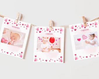 May include: Three white photo cards with pink hearts and a baby's photo on each card. The cards are labeled "NEWBORN", "1 MONTH", and "2 MONTHS".