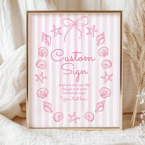May include: A framed sign with a gold border features a pink and white striped background. The sign has a pink seashell and starfish design around the text "Custom Sign". The text "Add any text you like" is also included.