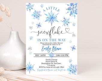 Op de afbeelding: Een blauwe en witte babyshower-uitnodiging met een sneeuwvlokkenontwerp. De uitnodiging luidt "A Little Snowflake is on the Way" en bevat de datum, tijd en locatie van de babyshower. Het bevat ook de naam "Emily Brown" en de RSVP-informatie.