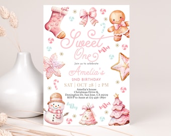 May include: Pink and gold Christmas-themed first birthday party invitation with a gingerbread girl, a snowman, a Christmas tree, and a snowflake. The invitation says "Sweet One" and "Amelia's 2nd Birthday".