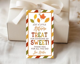May include: A gift tag with a white background and a colorful autumn-themed design. The tag features the text "JUST A LITTLE Autumn TREAT FOR SOMEONE SO SWEET! THANK YOU FOR ALL YOU DO! Love, Amelia" and illustrations of fall leaves.