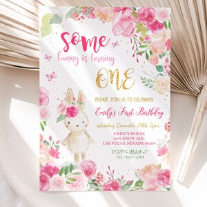 May include: A pink and gold first birthday invitation with a watercolor illustration of a bunny wearing a flower crown. The text reads "Some bunny is turning ONE. Please join us to celebrate Emily's First Birthday, Saturday, December 28th, 2pm. Emily's House, 5678 Snow Ave., Las Vegas, Nevada 89109. RSVP to Anna at 123-4567-8909."